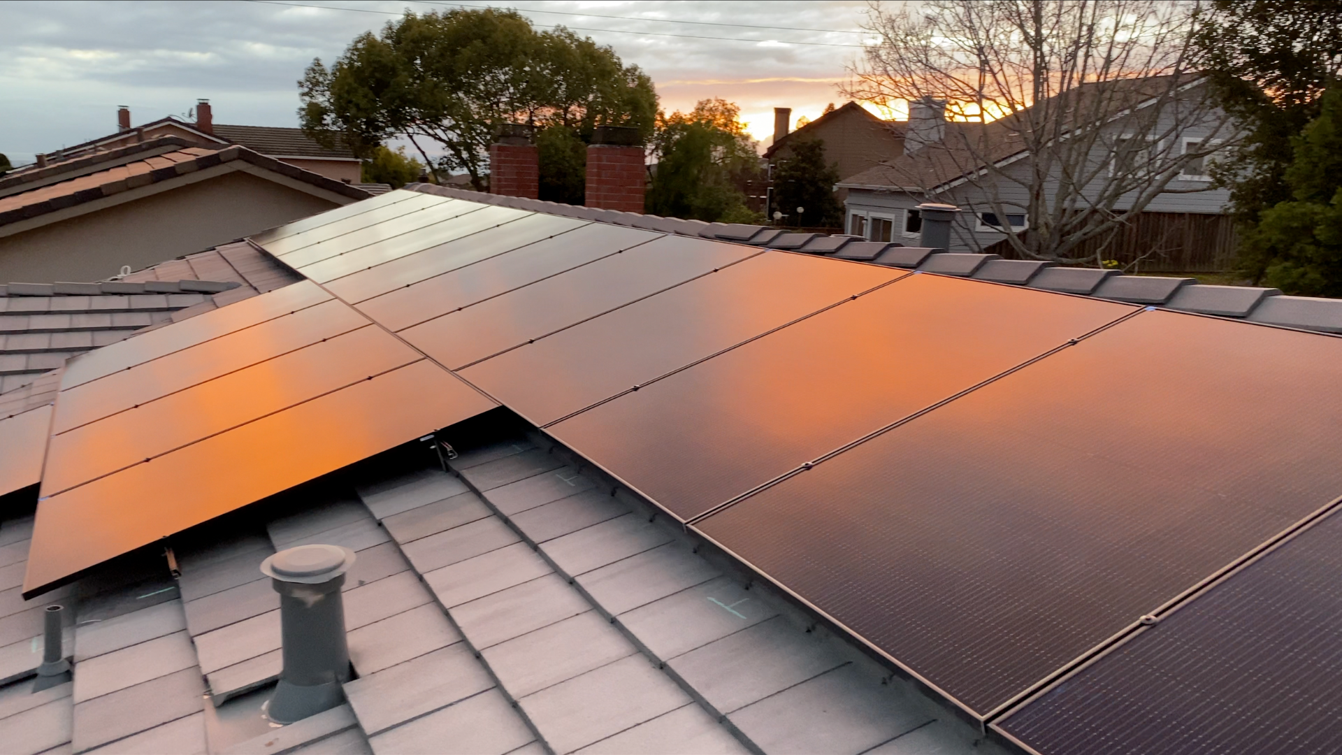 Enphase solar panels installed on a concrete tile roof at sunset