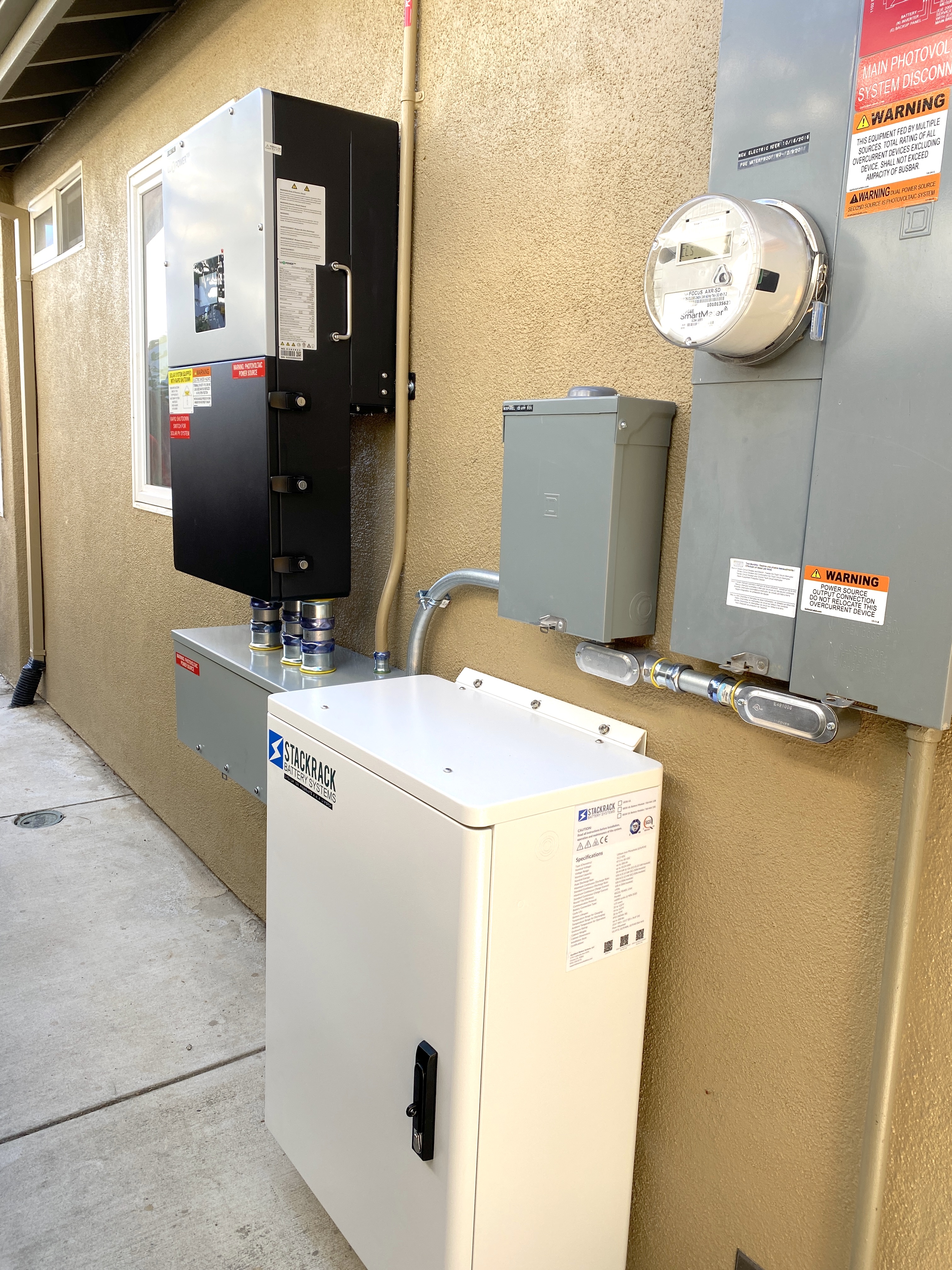 Battery storage cabinet, inverter, and PG&E meter mounted on the exterior wall