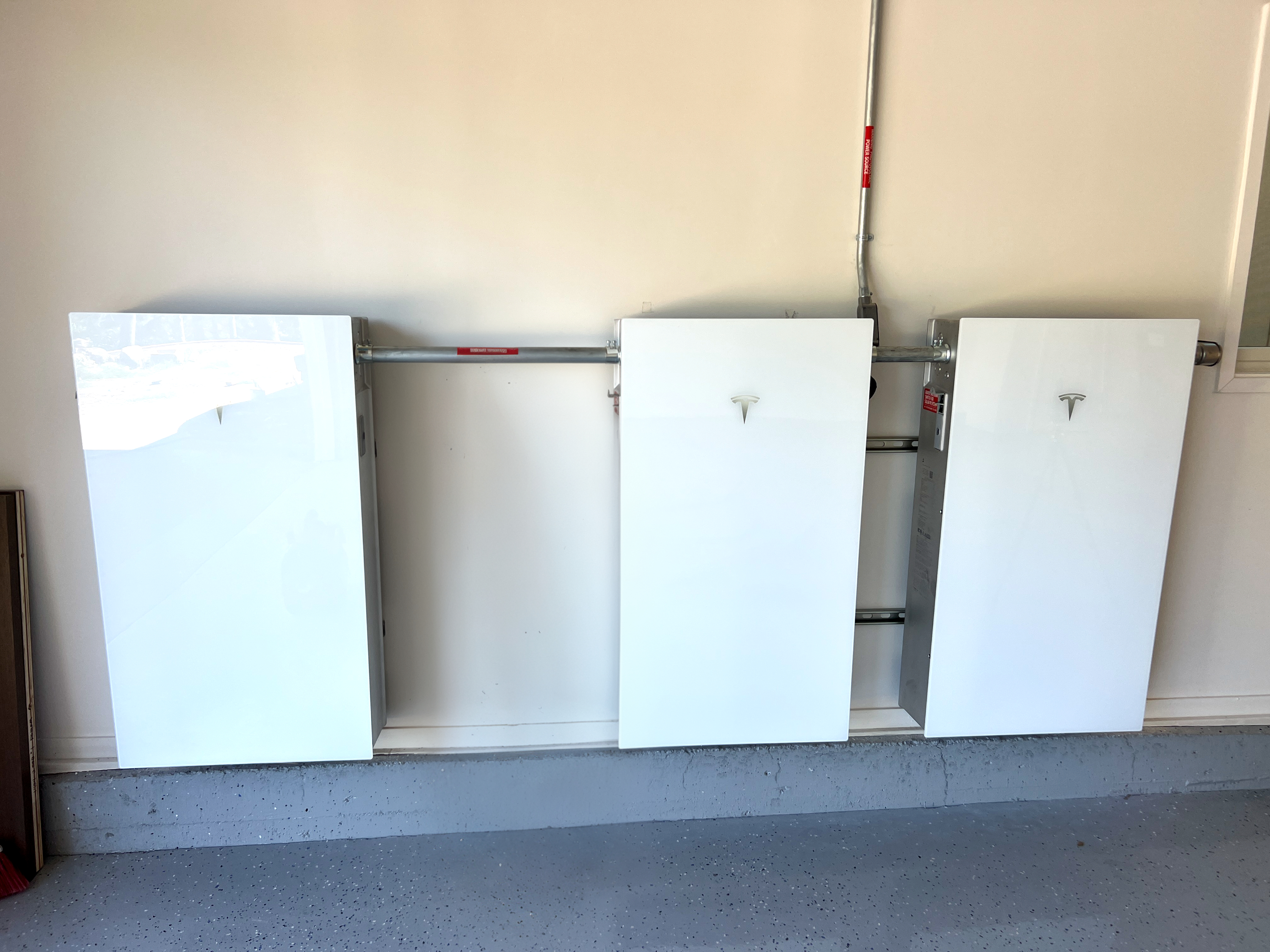 Three Tesla Powerwall batteries installed in a home garage